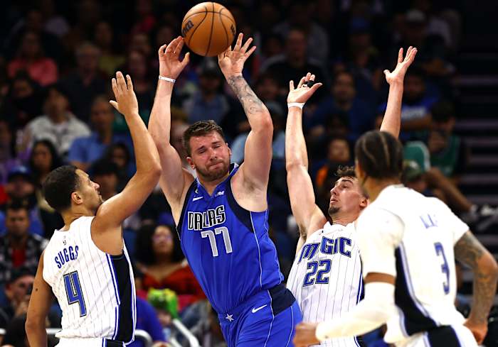 Dallas Mavericks guard Luka Doncic (77) drives to the basket as Orlando Magic guard Jalen Suggs (4) and forward Franz Wagner (22) defend during the second half at Amway Center.